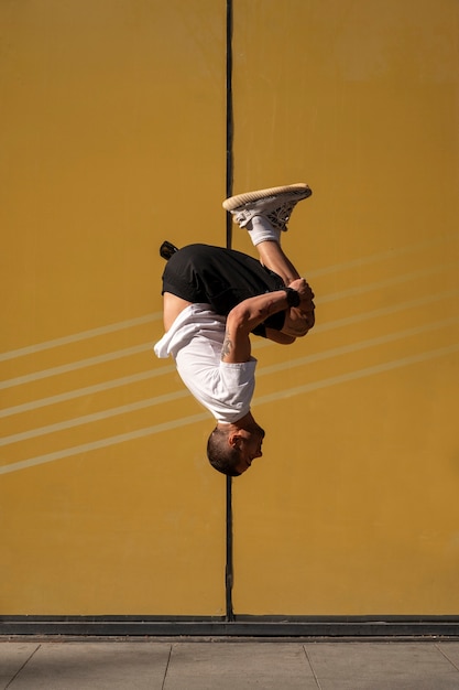 Foto grátis homem sem camisa praticando parkour ao ar livre