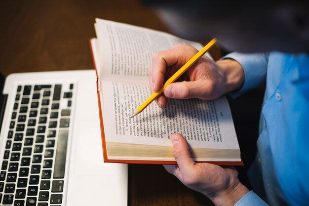 Homem sem rosto fazendo anotações no livro