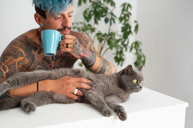 Foto grátis homem sendo carinhoso com gato plano médio