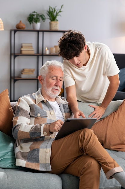 Homem sênior de tiro médio segurando o tablet