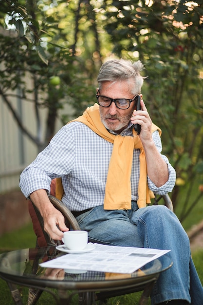 Foto grátis homem sênior falando ao telefone lá fora