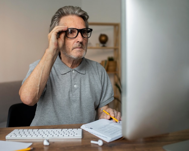 Homem sênior fazendo uma aula online em seu computador