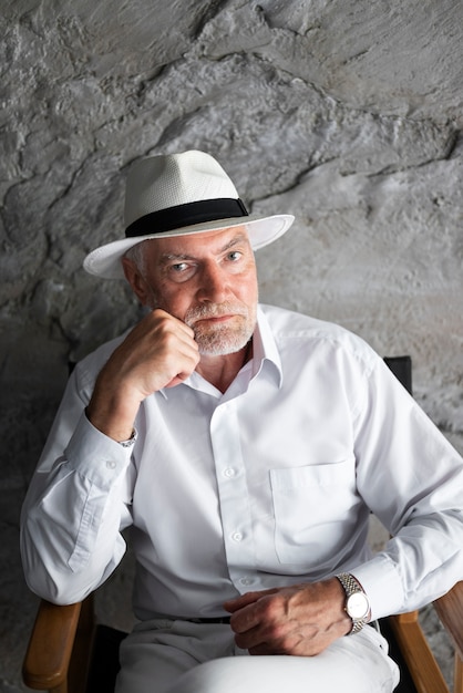 Foto grátis homem sênior posando de camisa branca e chapéu