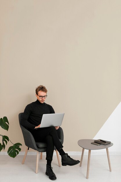 Homem sentado e trabalhando em um laptop