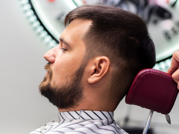 Homem sentado em uma barbearia