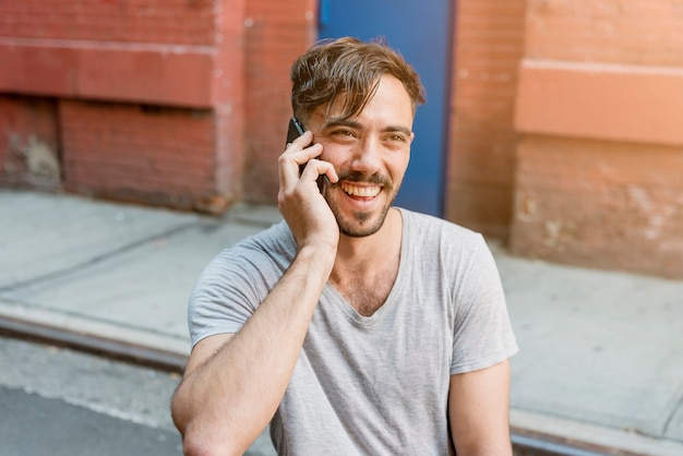 Homem sentado falando ao telefone