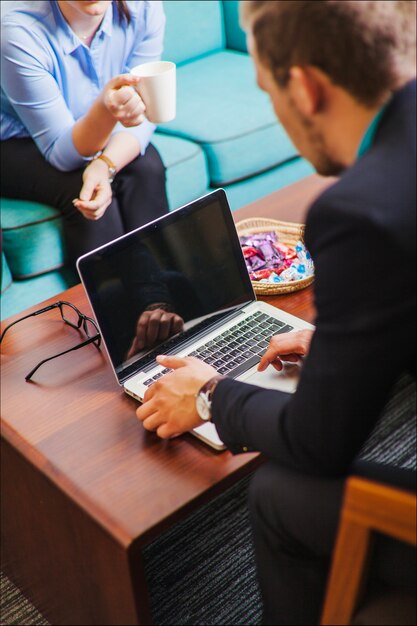 Homem sentado na cadeira com laptop