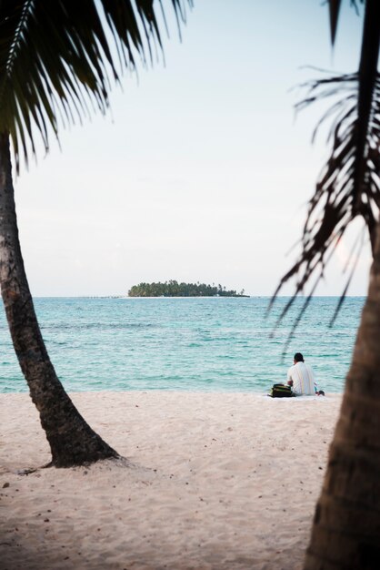 homem sentado na ilha tropical