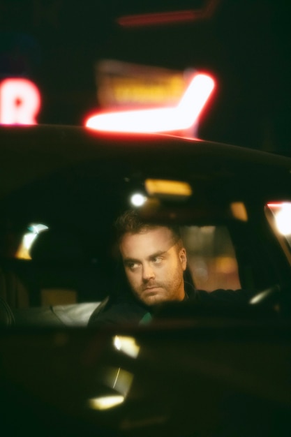 Homem sentado no carro a noite