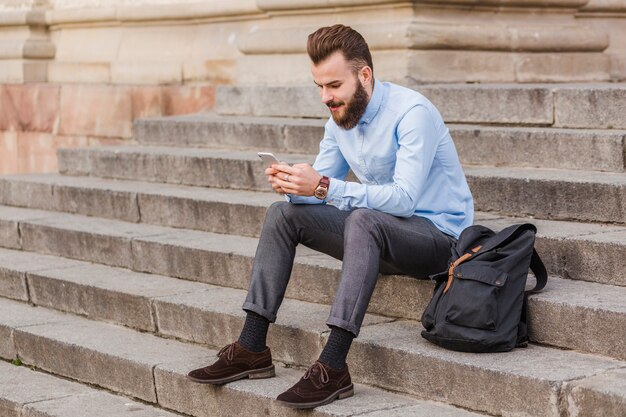 Homem, sentando, ligado, escadaria, usando, cellphone