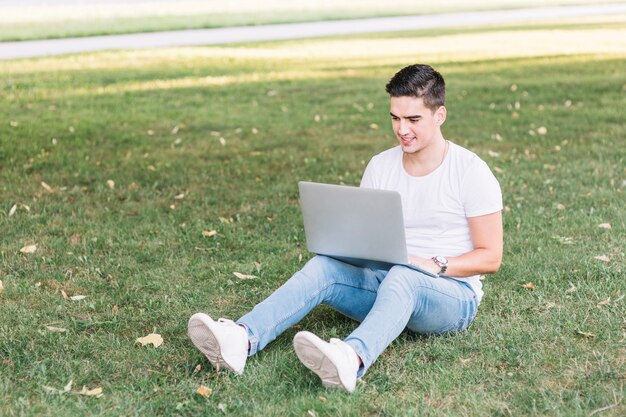 Homem, sentando, parque, usando, laptop