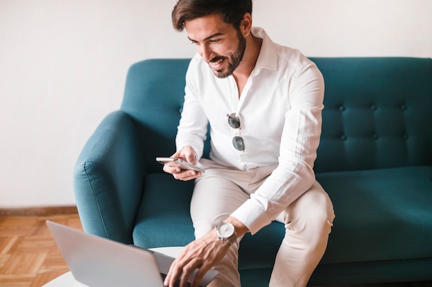 Homem, sentar sofá, trabalhando, laptop