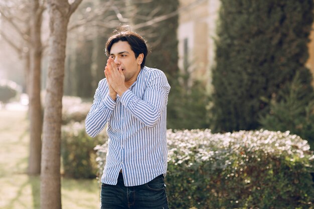 Homem sentindo frio em uma camisa no parque. Foto de alta qualidade