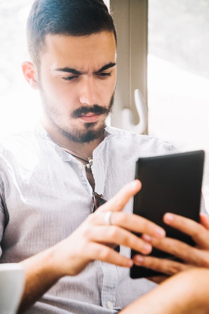 Homem serio assistindo smartphone