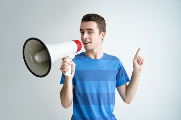 Homem sério falando no megafone e apontando para cima