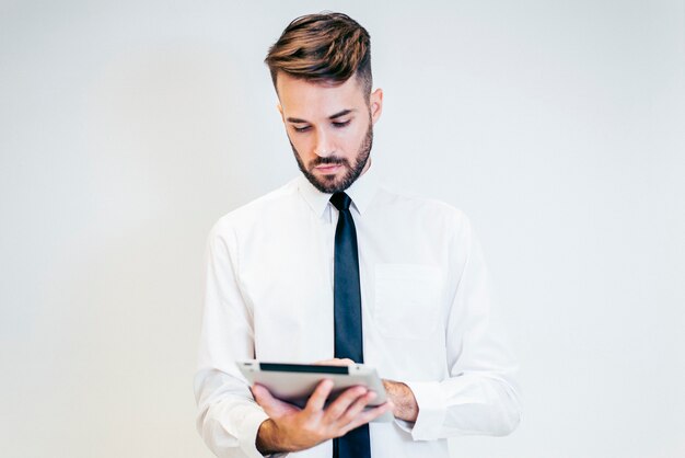 Homem sério olhando para um tablet