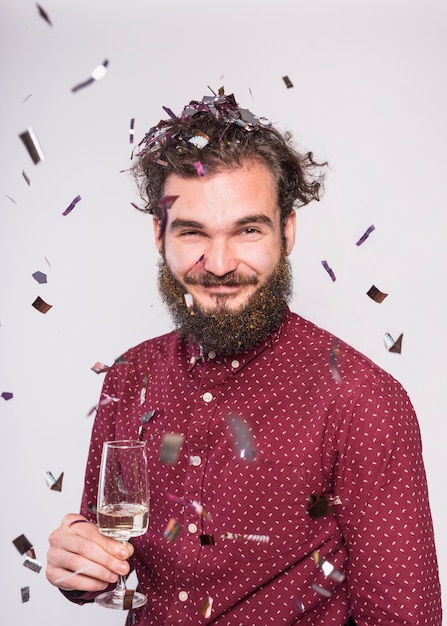 Homem sob lantejoulas com taça de champanhe