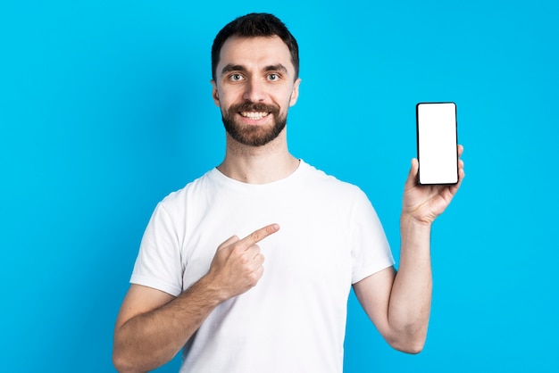 Homem sorridente apontando para smartphone