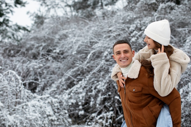 Foto grátis homem sorridente carregando namorada, tiro médio