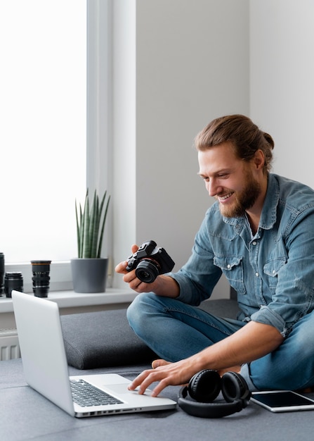 Foto grátis homem sorridente com câmera e laptop