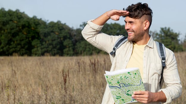 Homem sorridente com foto média segurando mapa