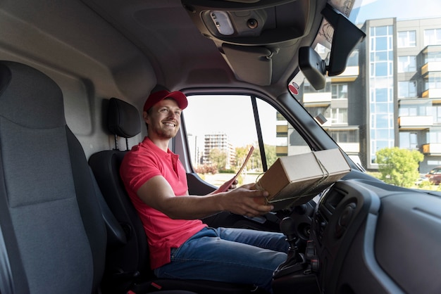 Homem sorridente com pacote no carro