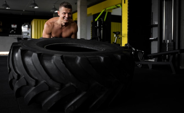 Foto grátis homem sorridente com tiro médio na academia