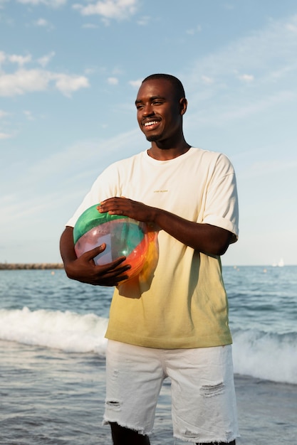 Homem sorridente com tiro médio segurando uma bola