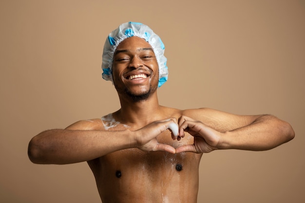 Foto grátis homem sorridente com tiro médio usando touca de banho