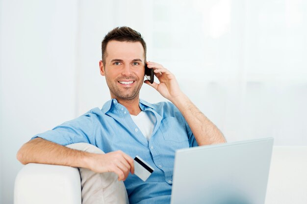 Homem sorridente comprando pela internet