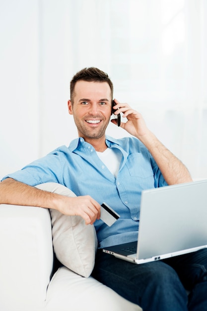 Homem sorridente comprando pela internet