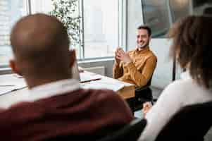 Foto grátis homem sorridente conversando com seus colegas durante uma reunião