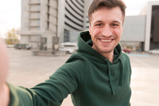 Homem sorridente de alto ângulo com capuz