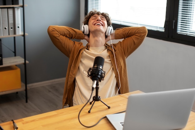 Foto grátis homem sorridente de alto ângulo gravando podcast