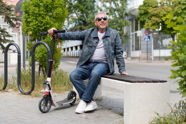 Homem sorridente de foto completa com scooter