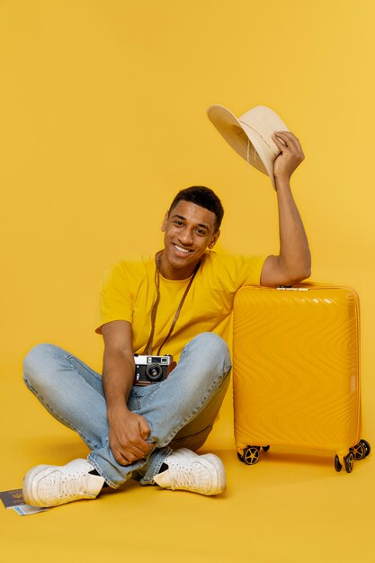 Homem sorridente de foto completa posando com bagagem