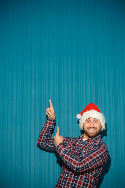 Foto grátis homem sorridente de natal usando um chapéu de papai noel