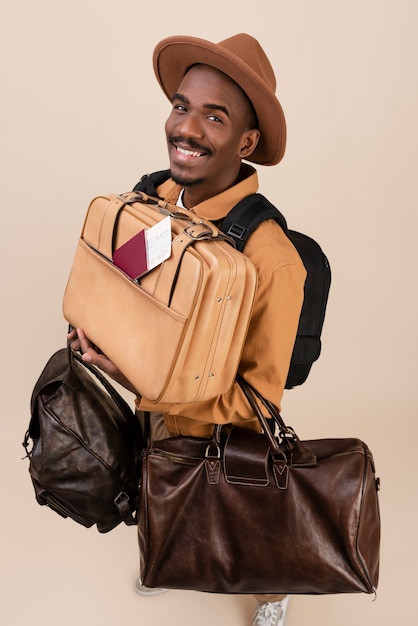 Homem sorridente de tiro completo carregando malas