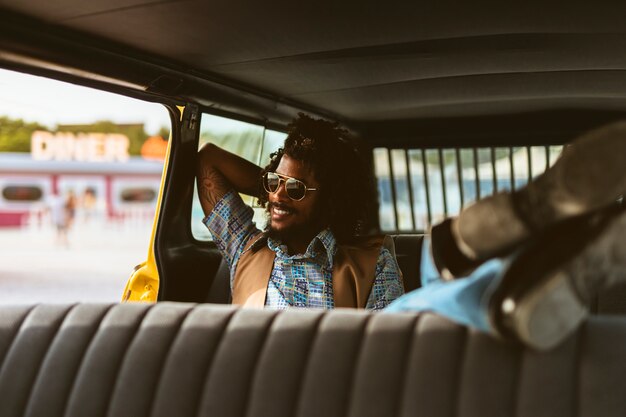 Homem sorridente de tiro completo no carro