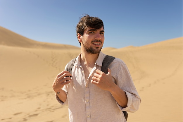 Homem sorridente de tiro médio carregando mochila