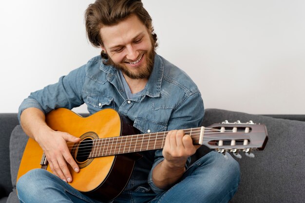 Homem sorridente de tiro médio com guitarra