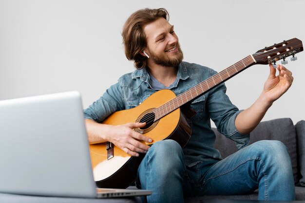 Foto grátis homem sorridente de tiro médio com guitarra