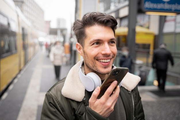 Homem sorridente de tiro médio com telefone