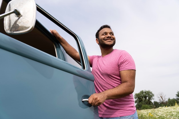 Homem sorridente de tiro médio com van