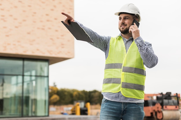 Homem sorridente de tiro médio falando ao telefone