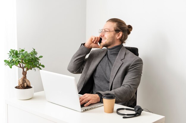 Homem sorridente de tiro médio falando no telefone