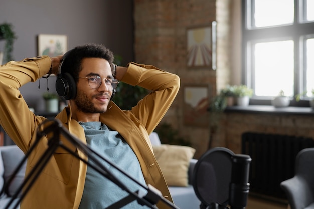 Foto grátis homem sorridente de tiro médio gravando podcast