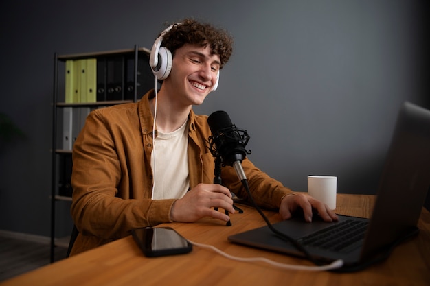 Homem sorridente de tiro médio gravando podcast