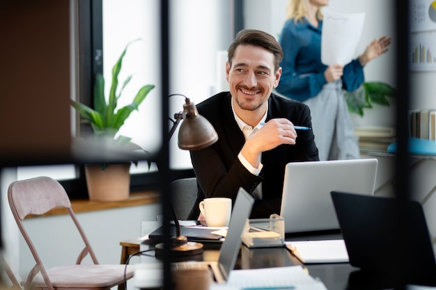 Homem sorridente de tiro médio na mesa