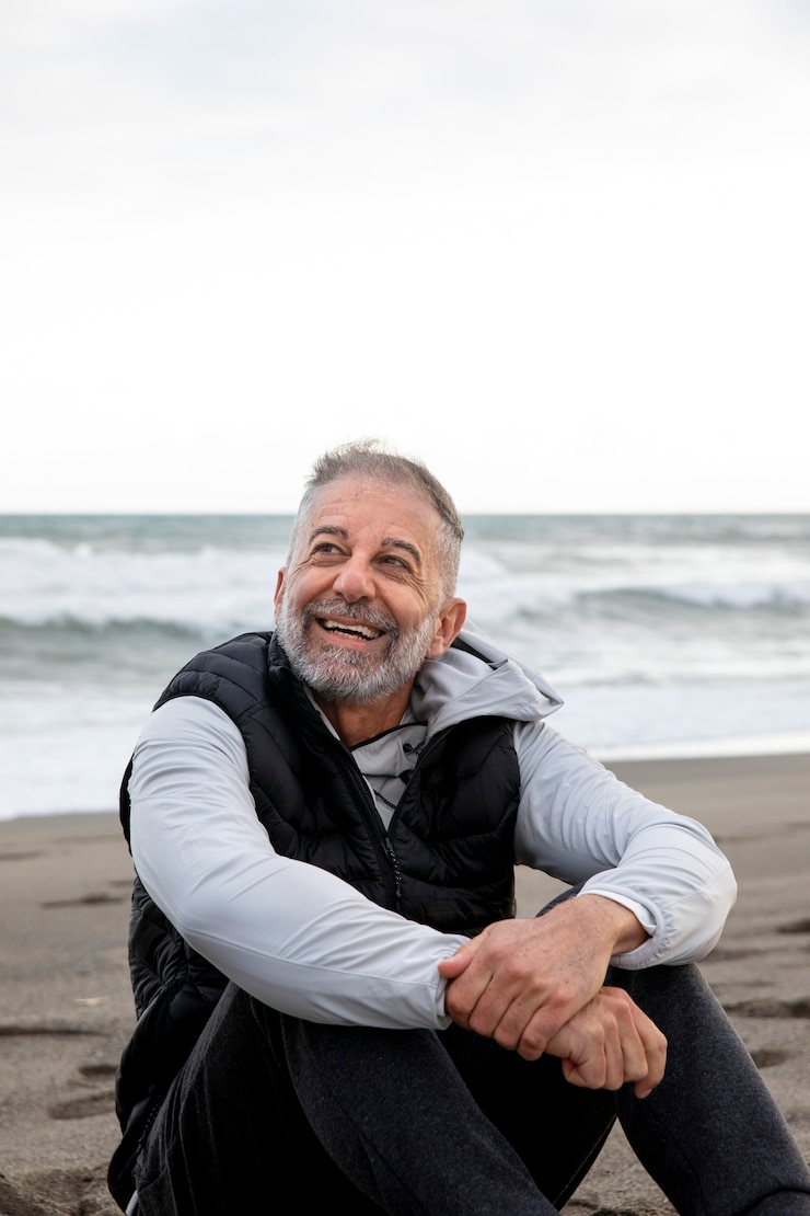 Foto grátis homem sorridente de tiro médio na praia